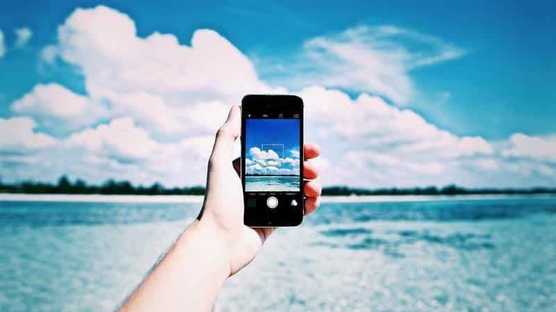 Voyager seule sans se sentir isolée : guide complet pour vivre un voyage solo équilibré 8 Femme utilisant un smartphone pour organiser son voyage et rencontrer des gens