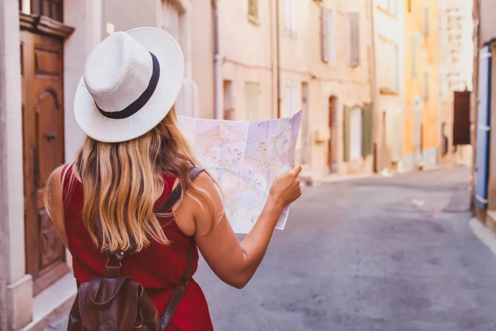 Voyager seule pour la première fois : guide complet pour un premier voyage solo réussi 9 Femme seule en voyage regardant un paysage au lever du soleil, symbole de confiance en soi et d’épanouissement après un premier voyage solo