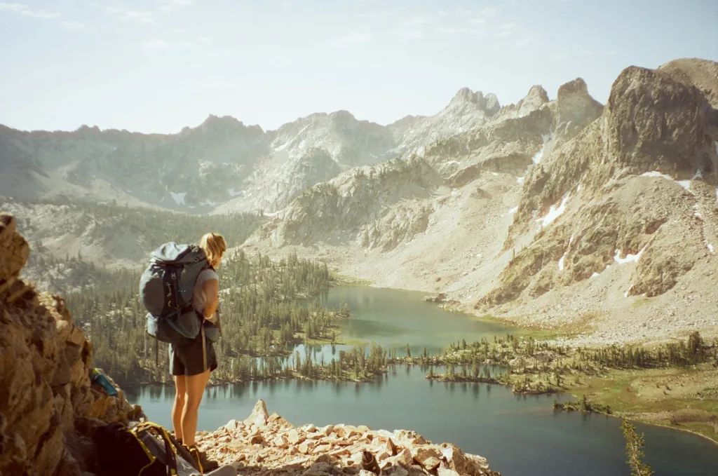 Voyager seule : un guide pour les femmes en quête d’aventure 12 Femme seule debout face à un paysage ouvert symbolisant la confiance en soi
